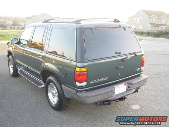 Rear view of a green 1997 Ford Explorer with tinted windows and a trailer hitch