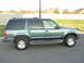 1997 Ford Explorer - Side view of a green SUV with tinted windows and running boards.