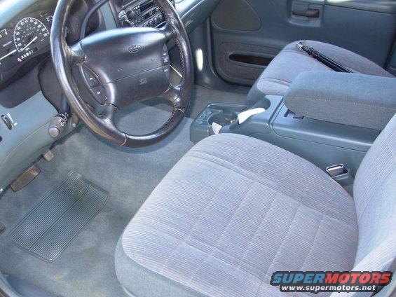 1997 Ford Explorer interior with grey striped cloth seats, dashboard, steering wheel, and center console