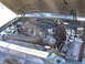1997 Ford Explorer - The engine bay of a vehicle is shown with the hood open, revealing various mechanical parts and wiring.