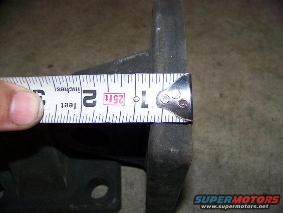 Tape measure against a dark metal object, showing about 2 inches