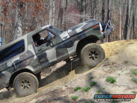 Camouflage Ford Bronco climbing dirt hill