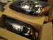2003 Ford Taurus - Two black aftermarket headlights are shown in their shipping boxes.