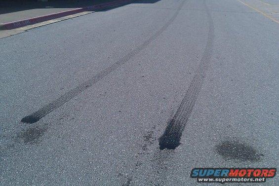Tire marks and fluid stains on asphalt road surface
