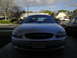 2003 Ford Taurus - Front view of a silver 2003 Ford Taurus parked in a driveway with another car to the right.