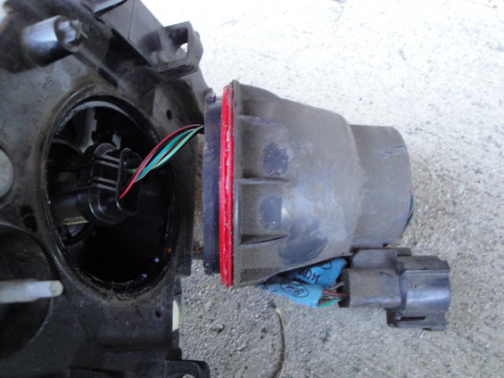 Car headlight assembly with wires and connector. Part of the assembly is detached
