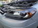 2003 Ford Taurus - Close-up of a 2003 Ford Taurus headlight and engine compartment.
