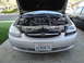 2003 Ford Taurus - Front view of a silver Ford Taurus, hood up, revealing the engine compartment and grille.