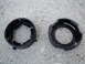 2003 Ford Taurus - Two black plastic headlight retaining rings are shown on a concrete surface.