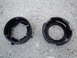 2003 Ford Taurus - Two black plastic headlight retainer rings are shown on a concrete surface.