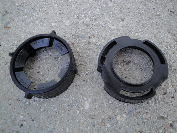 Two black plastic rings, one with Ford logo and part numbers like F243-18
