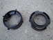 2003 Ford Taurus - Two black plastic headlight retainer rings are shown on a concrete surface. One ring has a Ford logo and part numbers visible.