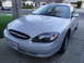 2003 Ford Taurus - This silver 2003 Ford Taurus is shown from the front quarter angle, displaying its headlights and grille.