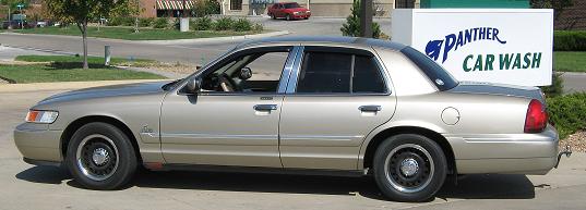 Gold 2000 Mercury Grand Marquis parked outside Panther Car Wash