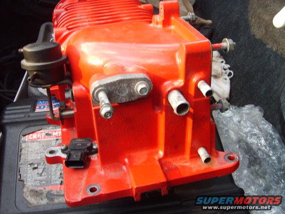 Red supercharger with black vacuum canister and sensor, resting on a Craftsman battery