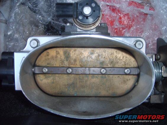 Throttle body with tarnished brass plate and visible screws