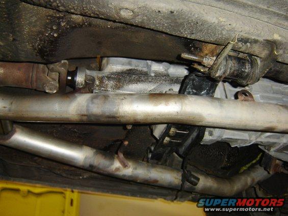 Underside view of a car's exhaust pipes and transmission housing