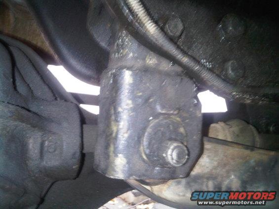 Close-up of a greasy suspension component with a bolt