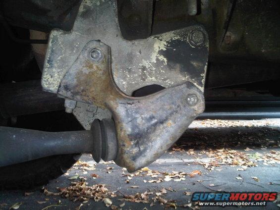 Close-up of a rusty suspension part with a rubber bushing