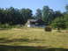 1989 Ford Bronco - A rural scene shows a house and hay bales under a clear blue sky.