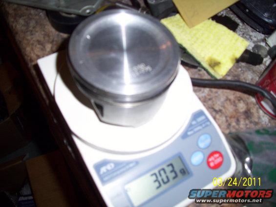 Piston on digital scale showing 303g. Date stamp 08/24/2011