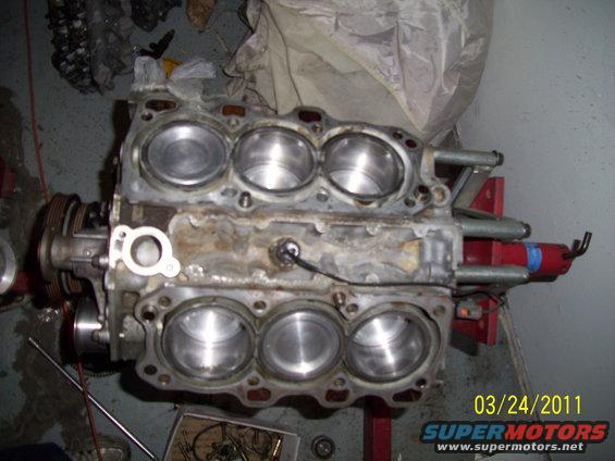 Engine block with cylinders visible, mounted on a stand