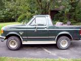 Side view of dark green 1989 Ford Bronco with tan pinstriping