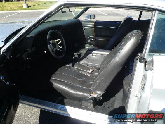 1973 Ford Torino interior with black vinyl seats, aftermarket steering wheel, and dashboard