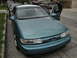 2003 Ford Taurus - A teal sedan is parked on the street with its doors open, and a man is standing next to it.