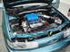 2003 Ford Taurus - The engine bay of a teal car is open, revealing the engine components and a blue intake manifold.