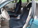 2003 Ford Taurus - The interior of a car features black racing seats and a beige dashboard, with the driver's side door open.