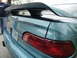2003 Ford Taurus - A teal sedan is viewed from the rear, its spoiler and taillight. The license plate is visible.