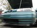 2003 Ford Taurus - The front of a teal sedan is shown with its hood open, revealing the engine bay.
