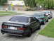 2003 Ford Taurus - A black Ford Taurus SHO is parked on the street, with two other vehicles behind it.