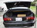 2003 Ford Taurus - Rear view of a black sedan with its trunk open, revealing a box and a California license plate.