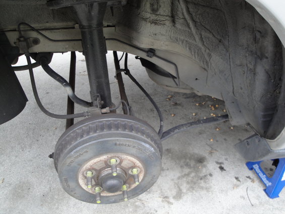 Rear drum brake assembly with shock absorber and suspension components