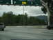 2003 Ford Taurus - Driving on the highway under a cloudy sky with a directional sign overhead.
