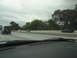 2003 Ford Taurus - Multiple vehicles travel along a highway under an overcast sky, with trees lining the roadside.
