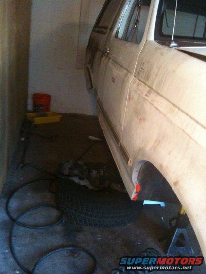 1995 Ford Bronco side view in a garage, raised on jack stands