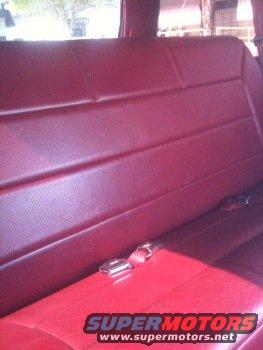Red interior seats with seatbelts. Supermotors.net logo visible
