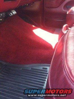 Red carpeted car interior with black floor mats and red leather seats