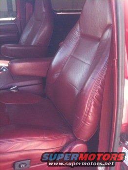 Red leather bucket seats with armrests inside a vehicle