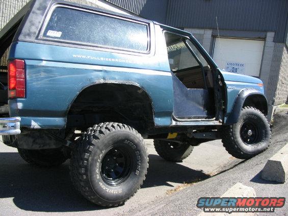 Blue 1986 Ford Bronco, 3/4 front view, lifted with off-road tires