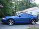 1999 Ford Mustang - Side profile of a blue 1999 Ford Mustang coupe with tinted windows.