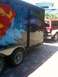 1995 Ford Bronco - A trailer with a Superman logo is parked next to a red and white SUV.