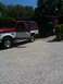 1995 Ford Bronco - A two-tone SUV is parked next to a trailer adorned with a Superman logo.