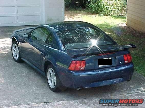 Dark blue 1999 Ford Mustang coupe, rear 3/4 view, parked on driveway