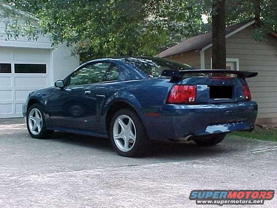blue Mustang parked in driveway, rear view