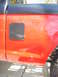 1992 Ford Ranger - Side view of a red truck a carbon fiber panel and two small lights on the body.