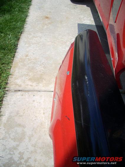 close-up of a red truck fender with a black trim piece